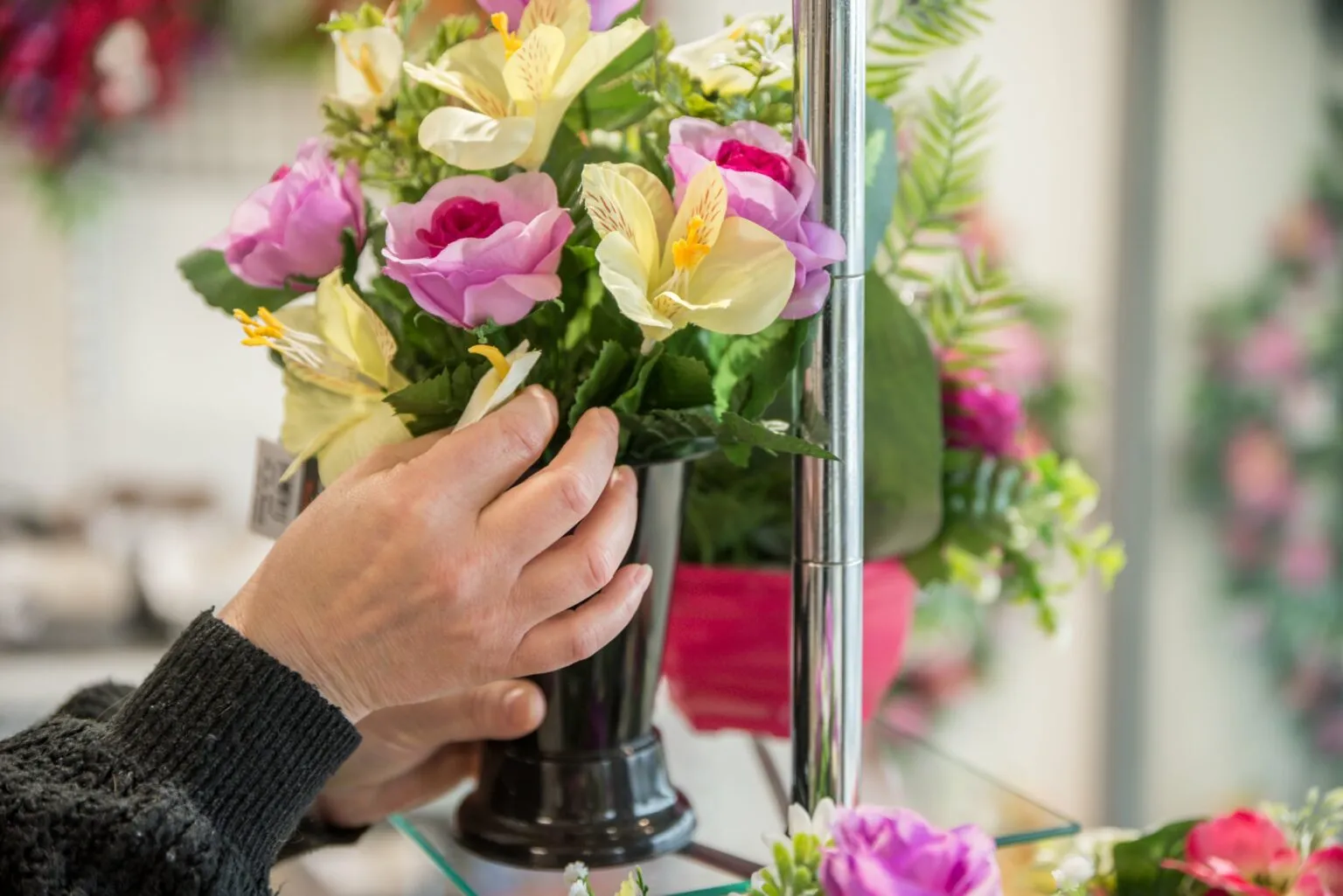Gros plan sur l'arrangement d'un vase de fleurs artificielles pour deuil dans un magasin