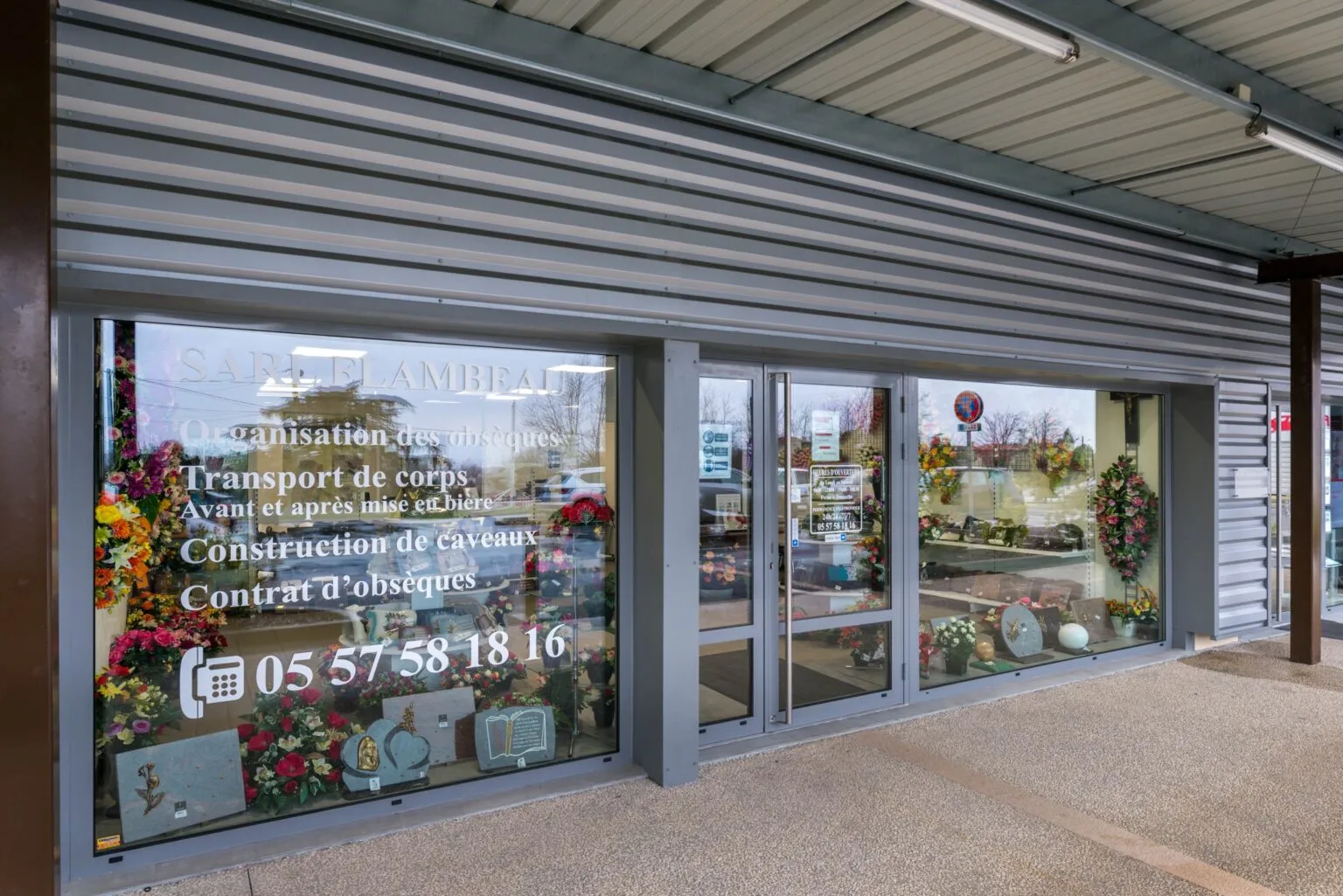 Vitrine de l'agence SARL Flambeau affichant les prestations d'obsèques et de marbrerie