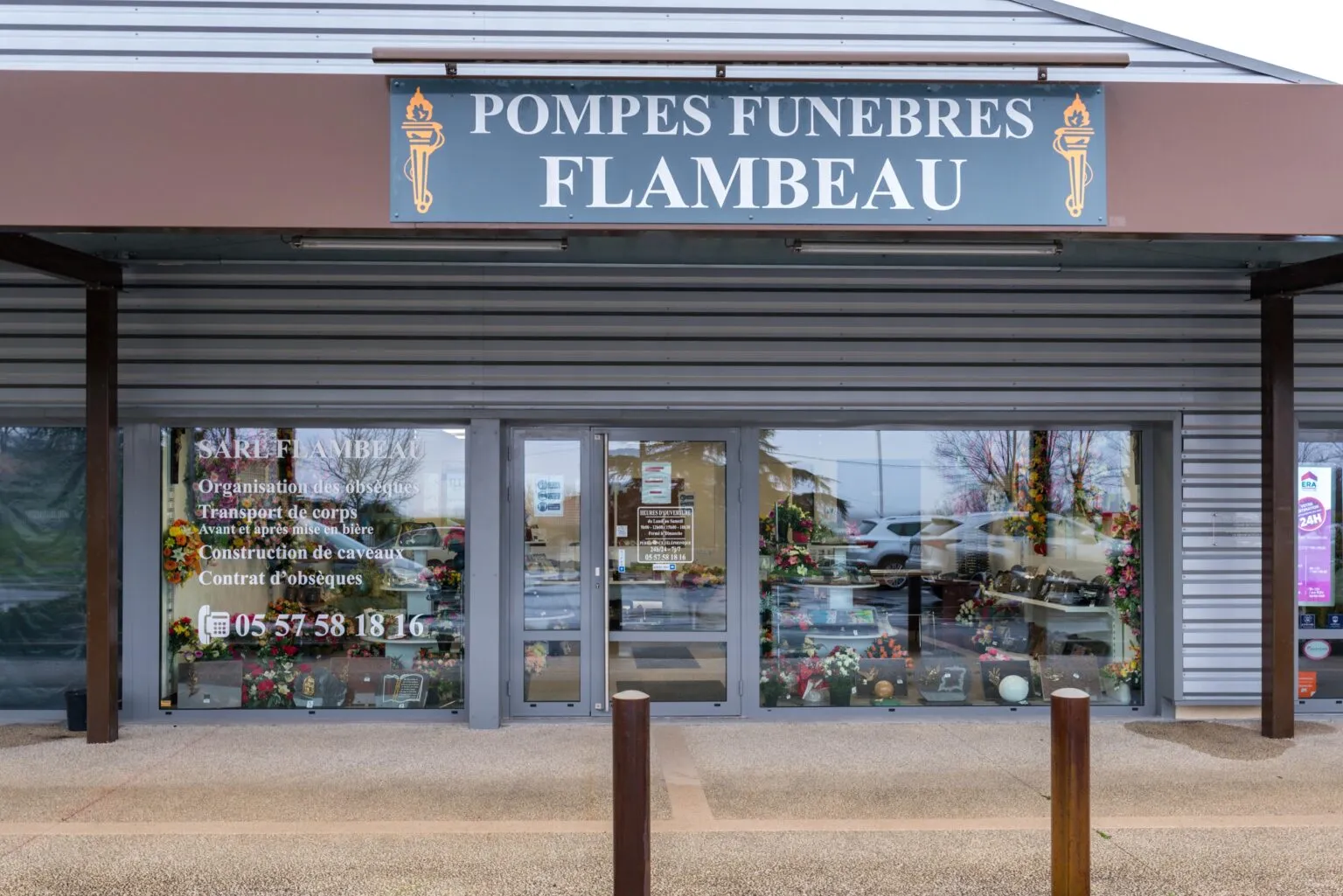 Devanture de l'agence de pompes funèbres Flambeau avec vitrines d'exposition d'articles funéraires