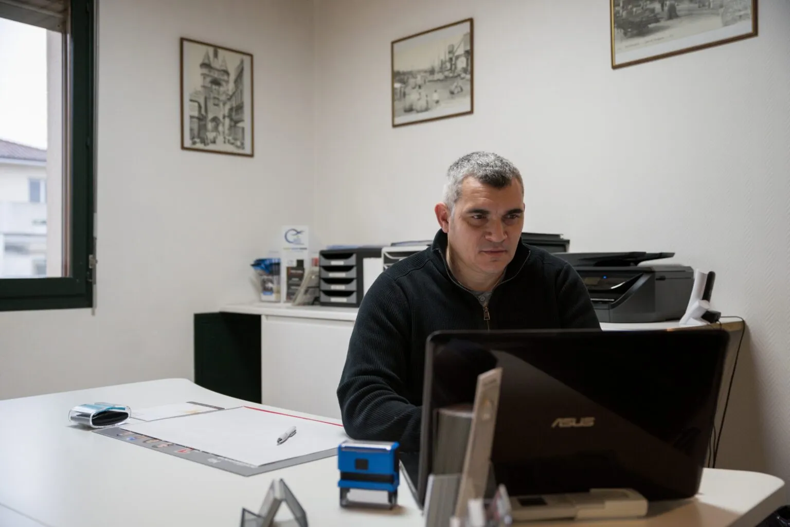 Conseiller funéraire travaillant sur ordinateur à son bureau d'accueil
